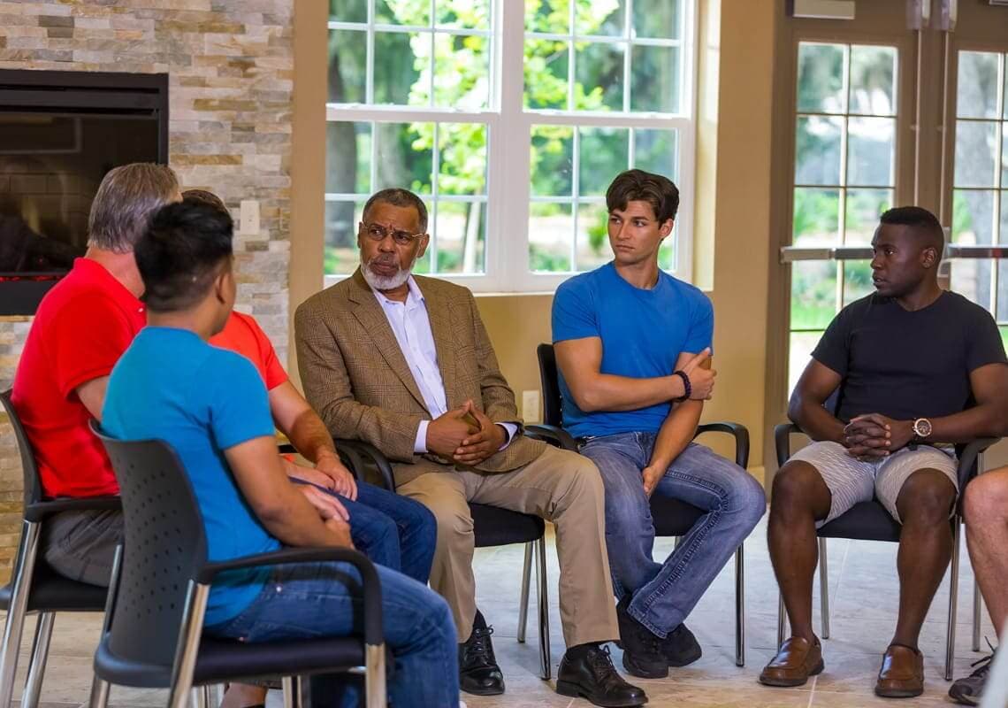 group of people sitting in chairs in a circle