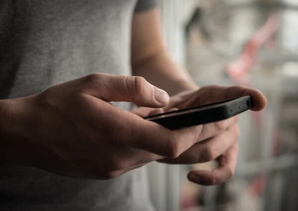 man holding cell phone making emergency call