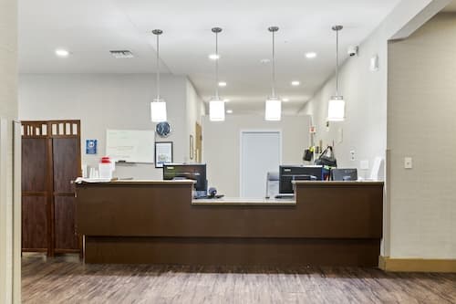 Wooden admissions desk with pendant lights above it