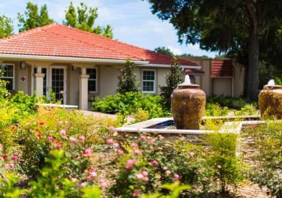 River Oaks rehab building with flowers and fountain in courtyard