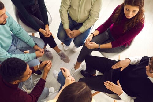 group of young people sitting in a circle during a group therapy session